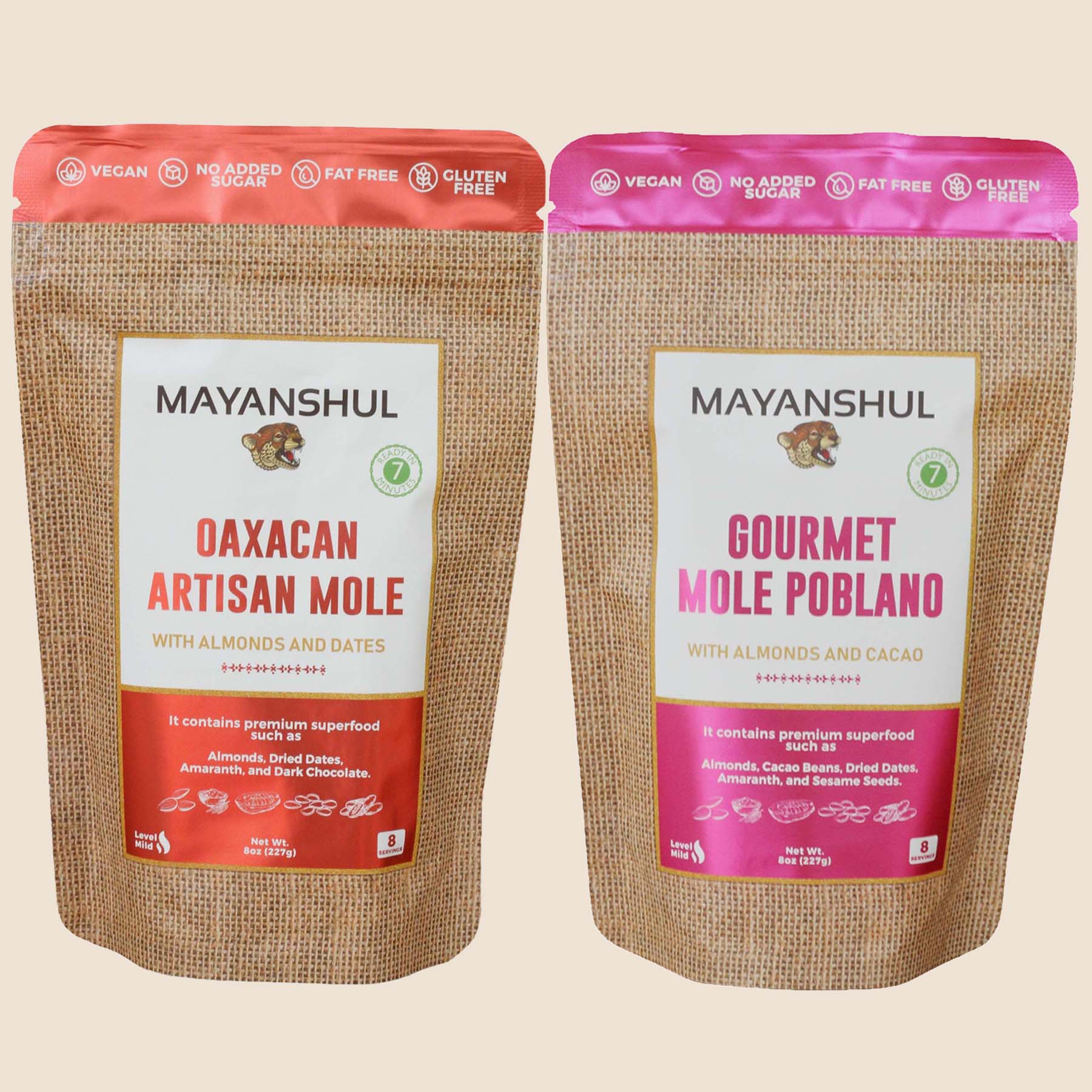 Two packages of Mayanshul mole sauce powder, one labeled as 'Oaxacan Artisan Mole' and the other as 'Gourmet Mole Poblano', with pink and red seals respectively.
